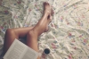 bacaklarının üzerinde kitap resmi paylaşan kız